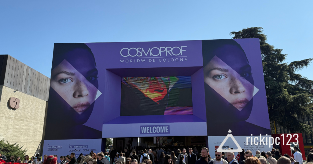 Ingresso principale di Cosmoprof Worldwide Bologna 2025 con maxi schermo e folla di visitatori