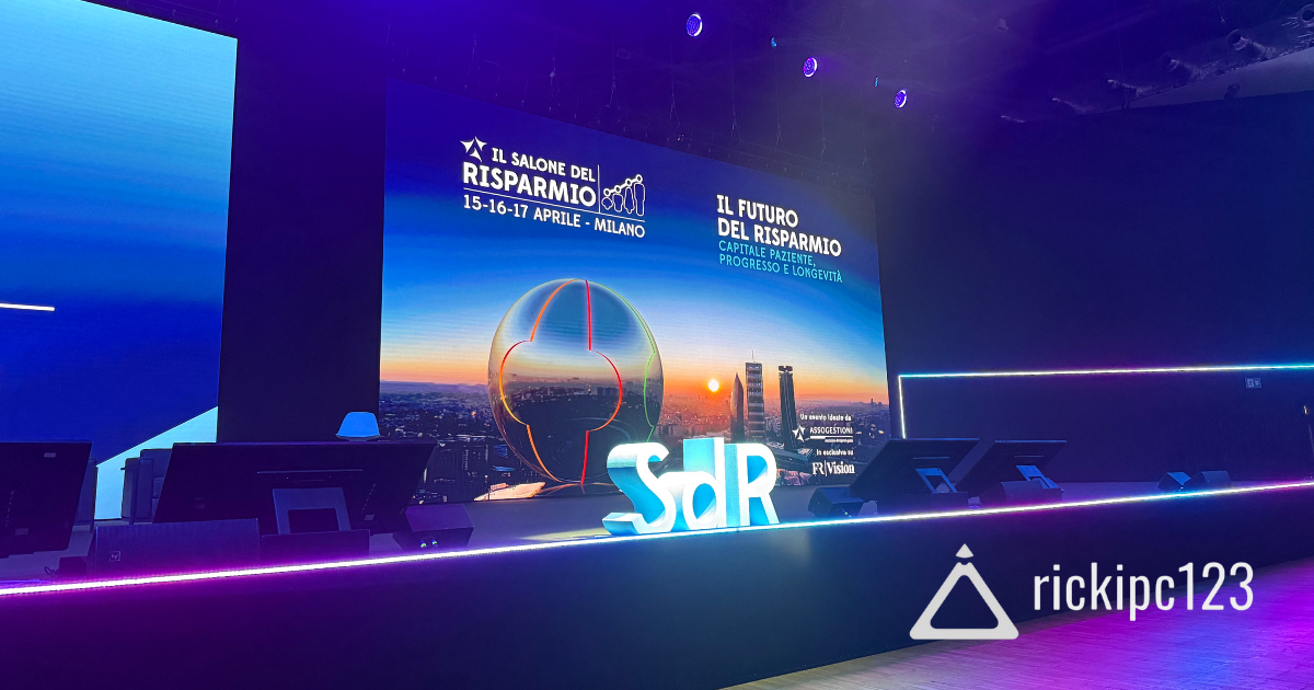 Palco del Salone del Risparmio 2025 al MiCo di Milano con lo schermo che mostra date, logo e tema dell’evento