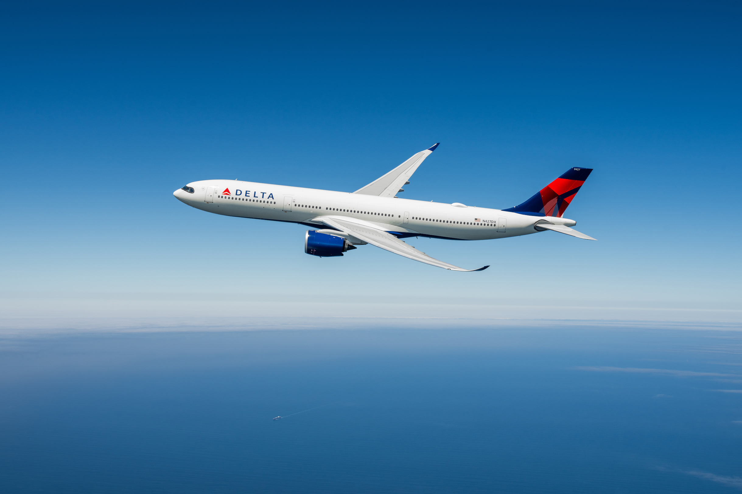 Aereo Delta A330-900neo in volo sopra l'oceano, utilizzato per il volo diretto Milano Boston Delta-owned. No expiration date, unrestricted use.